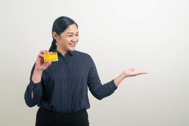 Azjatycka kobieta trzymająca kartę kredytową z białym tłem