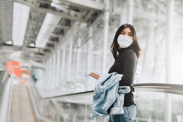 Azjatycka kobieta turysta na sobie maskę trzyma paszport