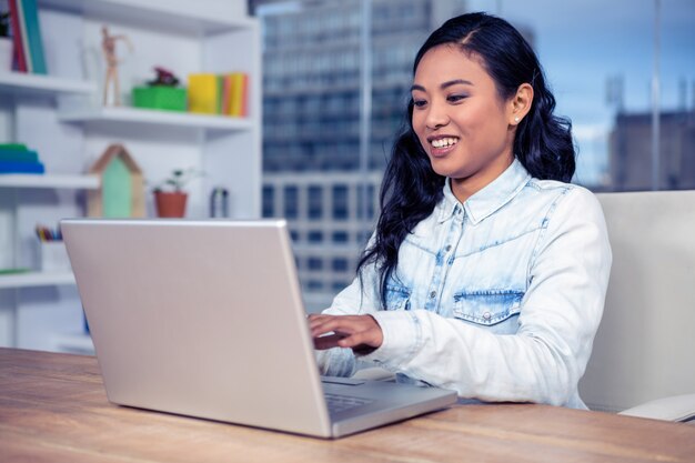 Azjatycka kobieta używa laptop w biurze