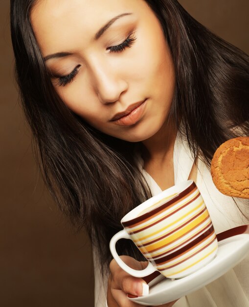 Azjatycka kobieta z kawą i ciastkami.