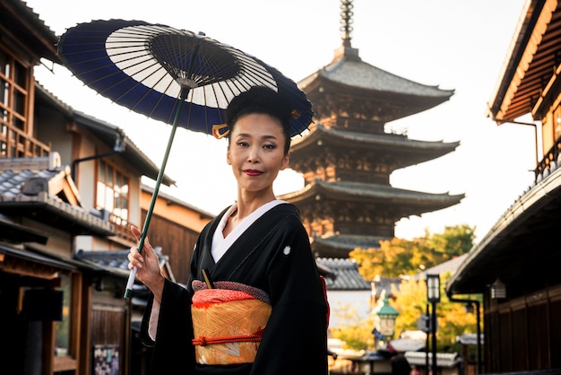 Azjatycka kobieta z kimonowym odprowadzeniem przy Yasaka pagodą w Kyoto