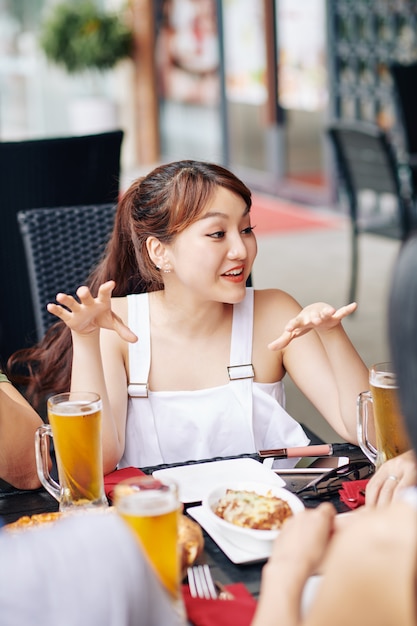 Azjatycka kobieta z przyjaciółmi w kawiarni