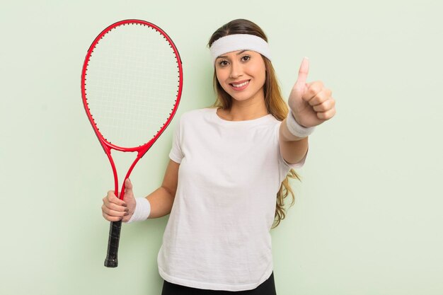 Azjatycka ładna kobieta czuje się dumnie uśmiechając się pozytywnie z kciukiem do góry tenisową koncepcją