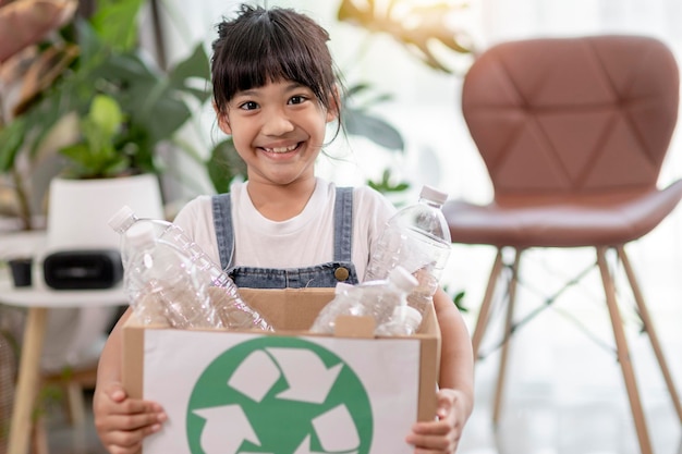 Azjatycka mała dziewczynka jest oddzielnym śmieciem do recyklingu