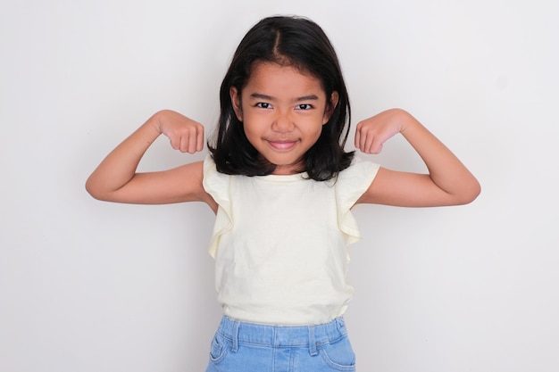 Azjatycka Mała Dziewczynka Pokazuje Jej Mięśnie Bicepsa Z Podekscytowaniem