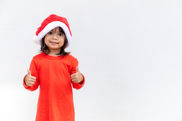 Azjatycka mała dziewczynka w czerwonym santa hat na białym tle.