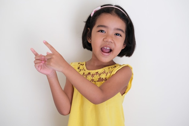 Azjatycka Mała Dziewczynka Wskazująca Palce Obok Z Wyrazem Szczęśliwej Twarzy