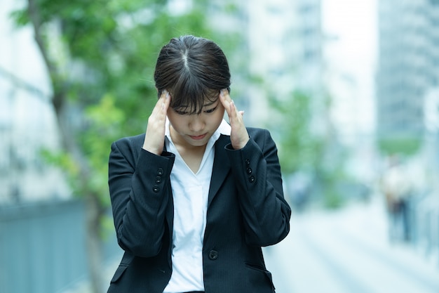 Azjatycka młoda kobieta cierpi na ból głowy