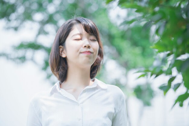 Azjatycka młoda kobieta ono uśmiecha się w parku