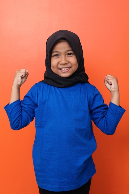Azjatycka muzułmańska dziewczynka szczęśliwa i podekscytowana świętuje zwycięstwo, wyrażając wielki sukces