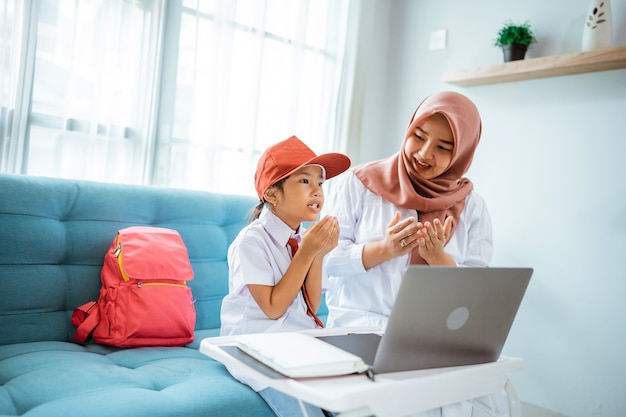 Azjatycka Muzułmańska Uczennica Modli Się Przed Rozpoczęciem Zajęć Online Z Domu