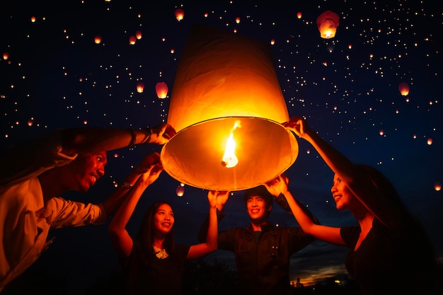 Azjatycka para podróżująca ustawiająca latarnię yi peng podczas uroczystości loi krathong w chiang mai