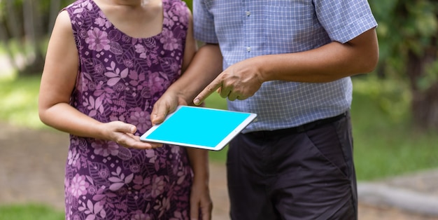 Azjatycka Para W średnim Wieku Rozmawia I Patrzy Na Tablet Razem Na Podwórku.