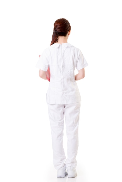 Azjatycka pielęgniarka kobieta, widok z tyłu pełnej długości portret na białym tle na białej ścianie.