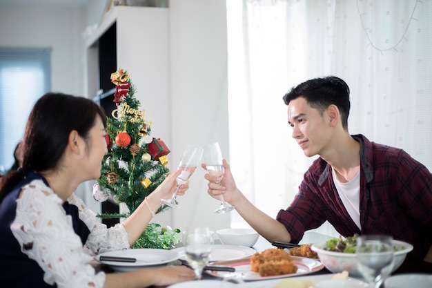 Azjatycka potomstwo para cieszy się romantycznego obiadowego wieczór pije podczas gdy siedzący przy łomotanie stołem dalej