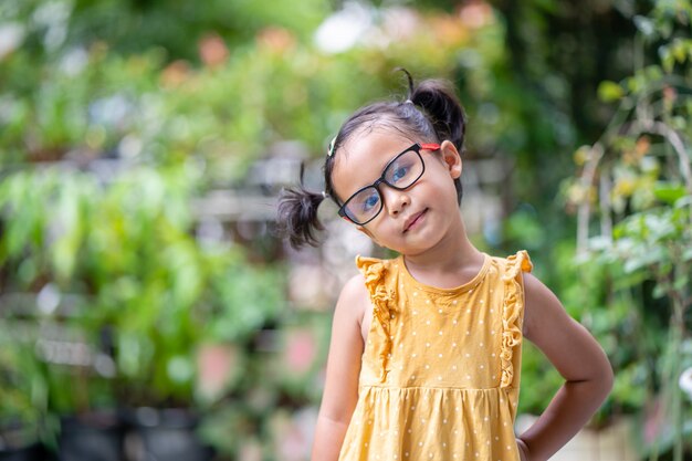 Azjatycka śliczna dziewczyna w okularach stojąca na zewnątrz