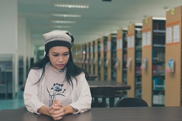 Azjatycka smutna dziewczyna w bibliotece w stylu vintagetajska kobieta stres z miłości koncepcja złamanego sercaciemny ton