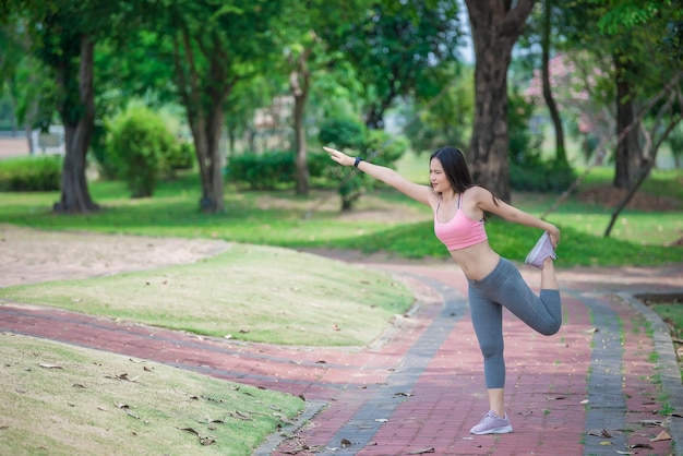 Azjatycka sportowa kobieta rozciągająca ciało oddychające świeżym powietrzem w parkuTajlandczycyKoncepcja fitnessu i ćwiczeń