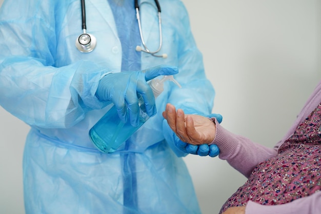 Azjatycka starsza kobieta naciśnij niebieski alkoholowy żel dezynfekujący do mycia rąk chroni przed koronawirusem infekcji