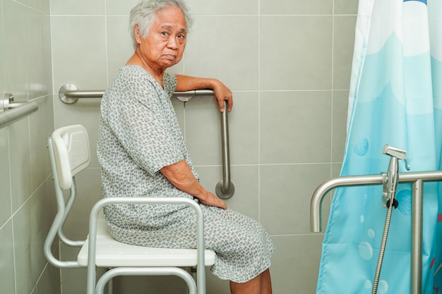 Azjatycka starsza starsza kobieta pacjent korzysta z poręczy toaletowej w łazience poręczy bezpieczeństwa szpitalnego
