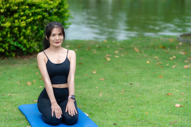 Azjatycka szczupła kobieta ćwiczy sama w parku Zmęczona treningiemGraj w koncepcję jogi