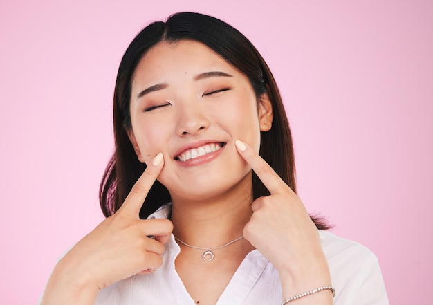 Azjatycka twarz i uśmiechnięta twarz do wybielania zębów i odnowy biologicznej lub urody na różowym tle w studio Pielęgnacja zębów i portret modelki ze szczęściem dla kosmetyków i stomatologii