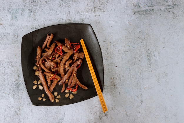 Azjatycka wołowina teriyaki z czerwoną ostrą papryką i chopstick.