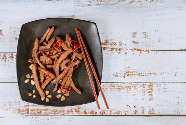 Azjatycka wołowina z grilla z papryczką chili i chopstick.