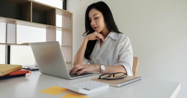 Azjatycki bizneswoman pracuje z przenośnym laptopem