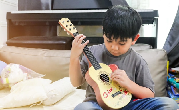 Azjatycki Chłopiec Uczący Się Gry Na Gitarze