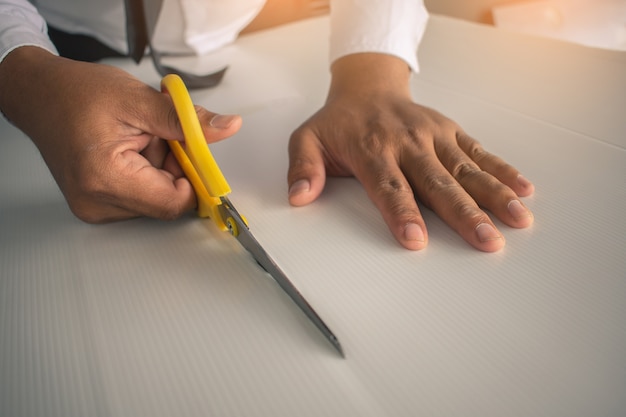 Azjatycki człowiek cięcia papieru z nożyczkami dla rzemiosła papieru