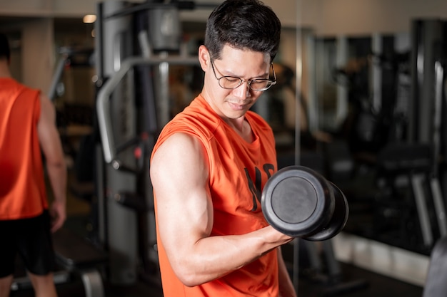 Azjatycki człowiek pracuje w siłowni fitness