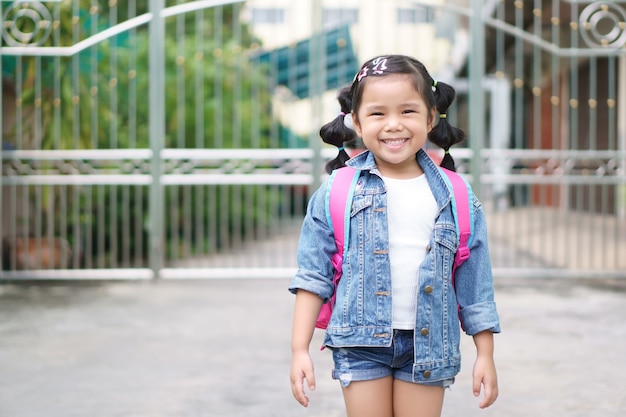 Zdjęcie azjatycki dziewczyna uśmiech i procy uczeń lub ramię różowy tornister