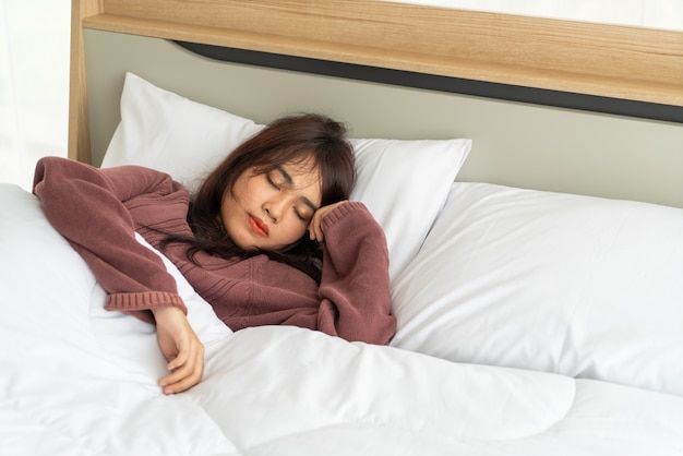Azjatycki kobiety dosypianie na łóżku w ranku