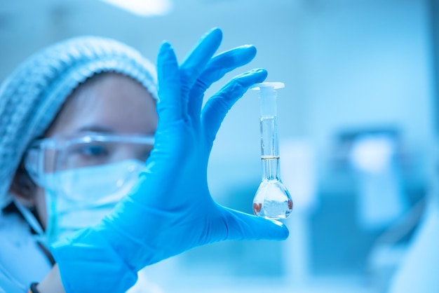 Azjatycki lekarz w laboratorium trzymający szklaną rurkę z płynnymi szczepionkami dla dzieci lub osób starszych lub leczący choroby zwierzątNaukowiec pracujący w laboratoriumTajlandczycy