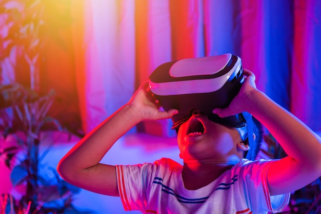 Azjatycki mały chłopiec noszący gogle wirtualnej rzeczywistości doświadczający rzeczywistości