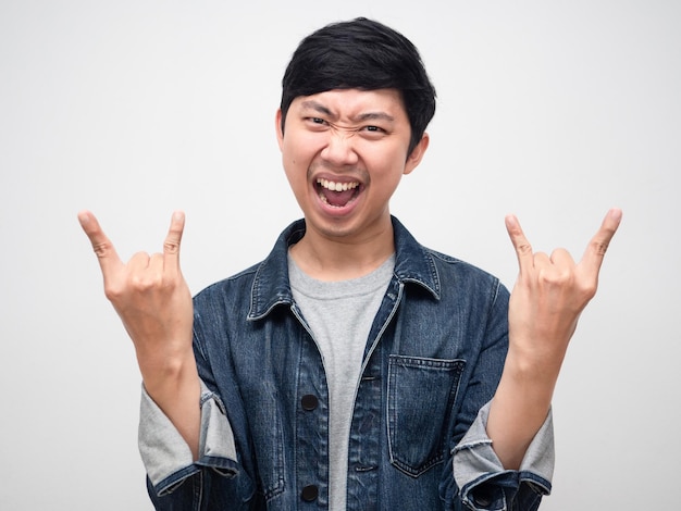 Azjatycki mężczyzna dżinsy koszula krzyczy gest rock and roll portret na białym tle
