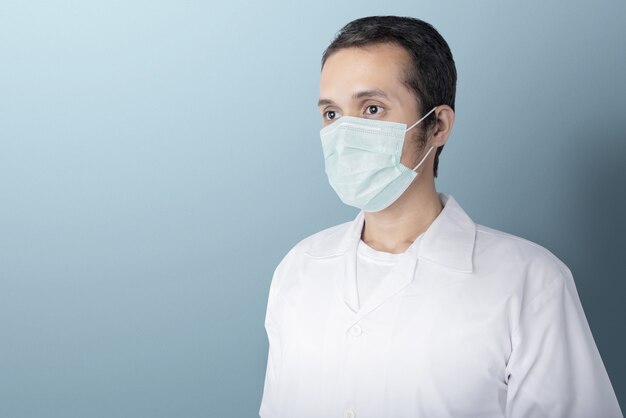 Azjatycki mężczyzna jest ubranym maskę przeciw grypie