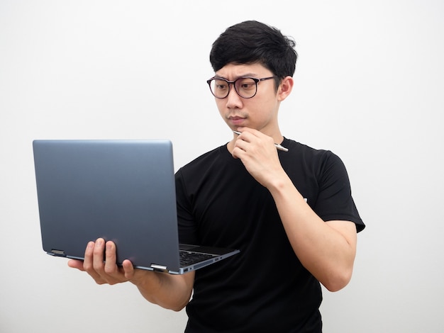 Azjatycki mężczyzna nosi okulary, używając laptopa, myśląc i czując zdezorientowaną poważną twarz na białym tle