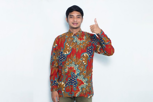azjatycki mężczyzna noszący batik z ok gestem gest tumb up na białym tle