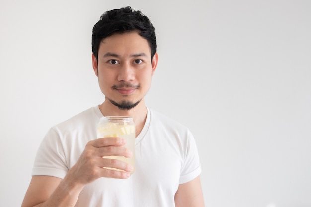 Azjatycki mężczyzna pije mrożoną sody cytrynowej na izolowanie białym tle.