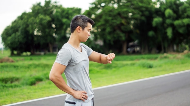 Azjatycki mężczyzna przygotowywa dla treningu przy jawnym parkiem, miękka ostrość.