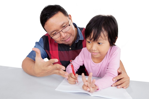 Azjatycki mężczyzna uczy córkę odrabiania lekcji