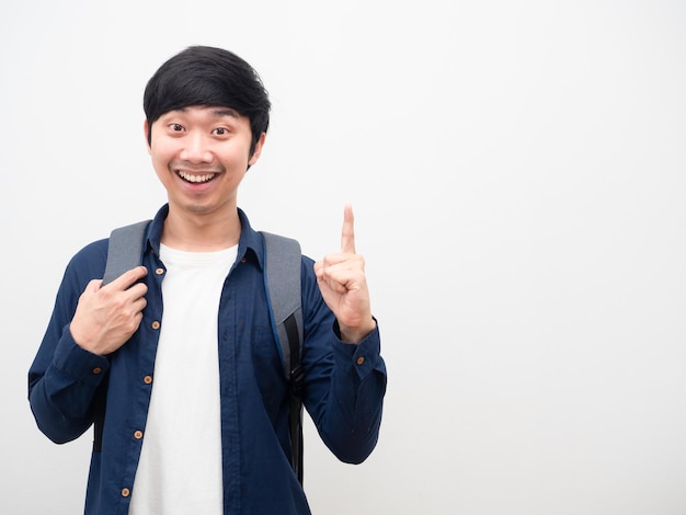 Azjatycki mężczyzna ze szkolnym plecakiem, uśmiechnięta twarz, wskazująca palcem w górę, pomysł, portret, kopia przestrzeń