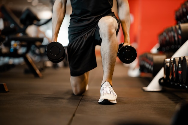 Azjatycki młody człowiek za pomocą ćwiczeń z hantlami na siłowni dla dobrego zdrowego w fitness Koncepcja stylu życia i ćwiczeń sportowych