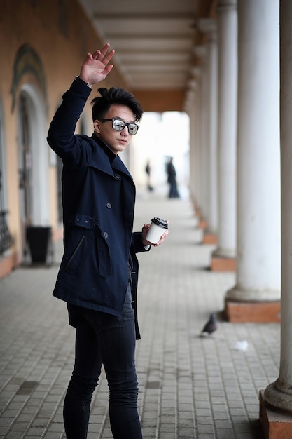 Azjatycki młody dorosły mężczyzna na ulicy pozuje do kamery