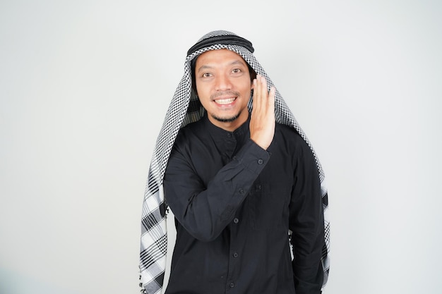 Azjatycki muzułmanin opowiada tajemnice w ustach szepcząc plotki nosząc arabski turban sorban w przestrzeni kopiowania