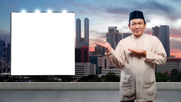 Azjatycki muzułmanin z otwartą dłonią pokazuje pusty billboard