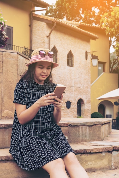 Azjatycki podróżnik używa smartphone podczas gdy podróżujący w Europa.