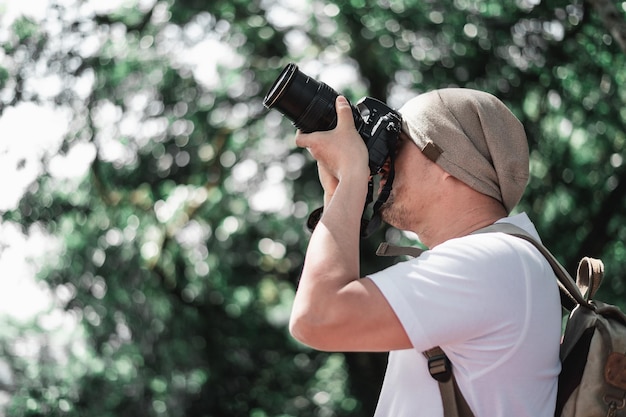 Azjatycki podróżnik z plecakiem robi zdjęcie w parku